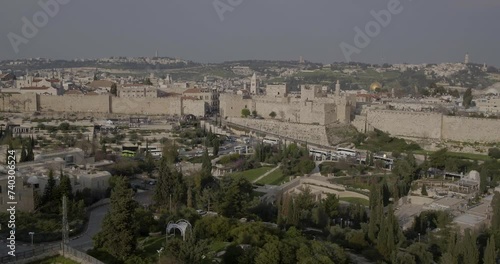 Aerial Footage of the Mishkenot Sha'ananim neighborhood in Jerusalem with the Old City walls, the Dome of the Rock and the Tower of David in the background.