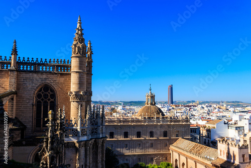 View from the Giralda Tower out over the roof and spires of the Seville cathedral with the city in view in Seville, Spain
