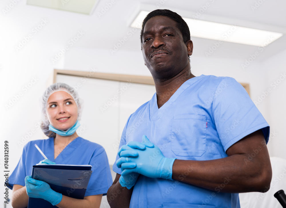 Obraz premium Portrait of two smiling successful male and female beauticians in modern clinic of esthetic medicine