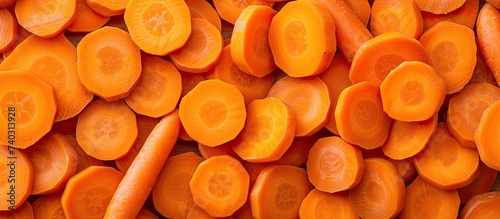 This photo showcases a pile of sliced carrots, raw and full of vitamins, arranged in a top-down perspective.