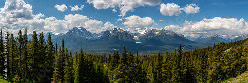 Wilderness views in Banff National Park during summer time with snow capped mountains on a blue sky, clouds day. Beautiful nature in Alberta, British Columbia