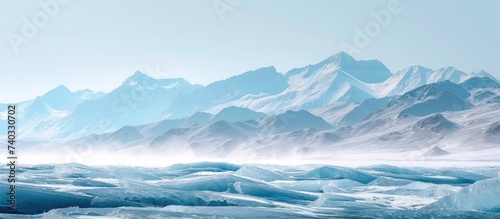 A stunning view of a glistening mountain range covered in snow and ice, set against the frozen Lake Baikal. © AkuAku