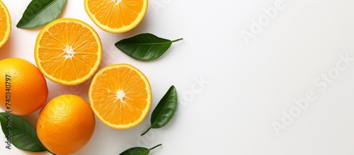 Bright fresh oranges and green leaves on a clean white background for vibrant natural concept