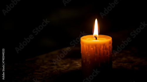 Close-up of a single unlit candle in a dark room.
