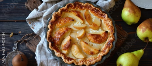 A delicious homemade pear pie made with fresh pears and creamy cottage cheese, sitting enticingly on top of a wooden table.