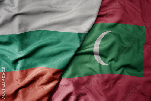 big waving national colorful flag of maldives and national flag of bulgaria .