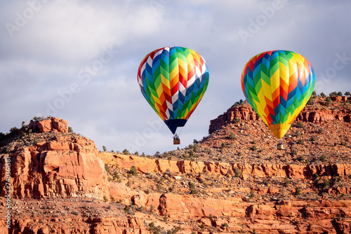 bright hot air balloons floating over southern Utah desert
