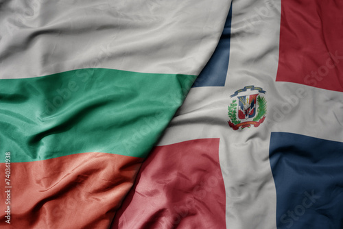big waving national colorful flag of dominican republic and national flag of bulgaria . photo