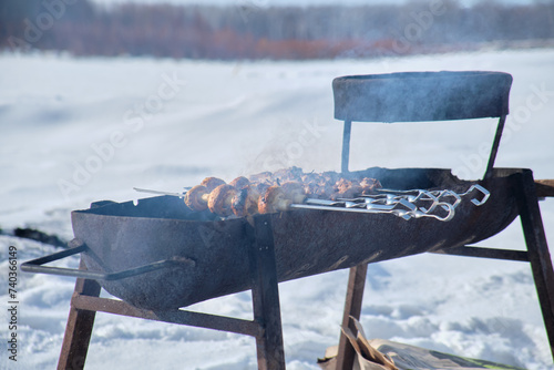 Barbecue meat on the grill on the fire in the open air. Russia. Winter.