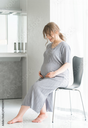 家のリビングで椅子に座る妊婦・マタニティフォト 