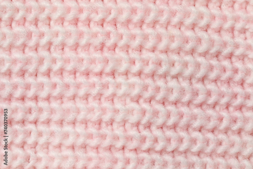 Texture of soft pink knitted fabric as background, top view