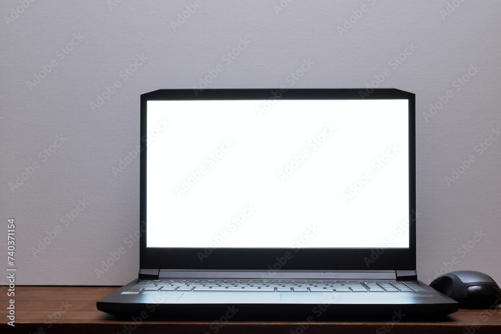Front on minimalistic image black Laptop clear white screen wooden desk grey background copy space Front on minimalistic image black Laptop clear white screen wooden desk grey background copy space