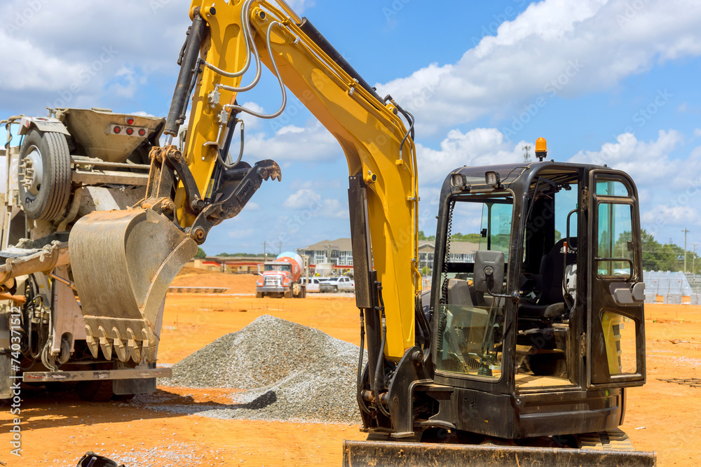Excavator working on an industrial site under infrastructure development Excavator working on an industrial site under infrastructure development