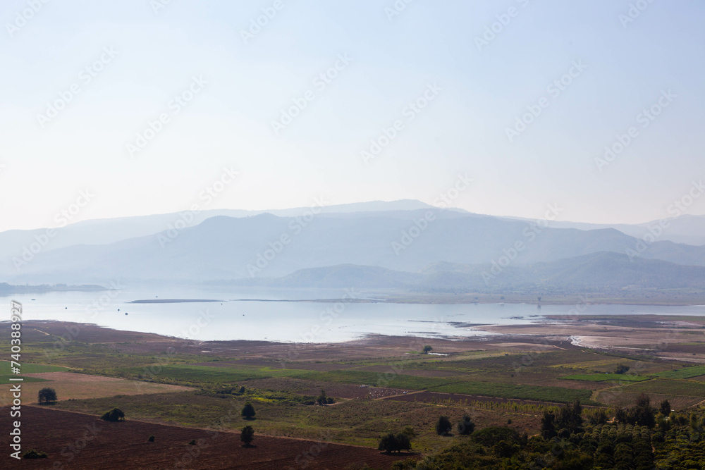 Obraz premium Doi Tao Lake and mountain view in North Thailand. Beautiful landscape with water, forests, and clear skies.