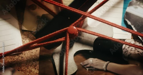 Close pan shot of the investigative board with crime scene photos and red strings connecting the evidence photo