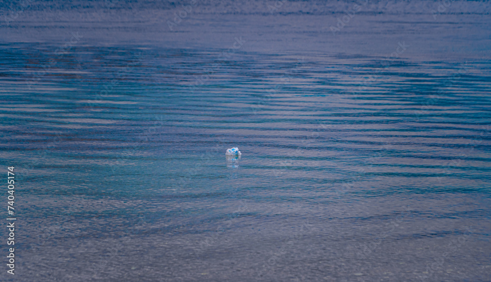 a plastic paper littering the beautiful blue sea