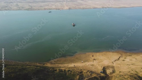 Aerial Drone shot of a traditional wood boat in blue Chambal River in Morena Dholpur of Madhya Pradesh Rajasthan in India photo