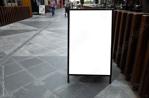 Blank white mockup template of a sandwich board in the dining area of a shopping centre. Background texture of empty advertising standing sign for restaurants or cafes. Copy space for your design photo