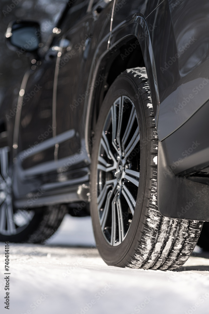 Close-up of a winter tire. Detail of car tires in winter on a road covered with snow.