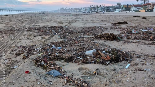 Trash plastic waste and sea garbage on sandy Manhattan Beach California photo