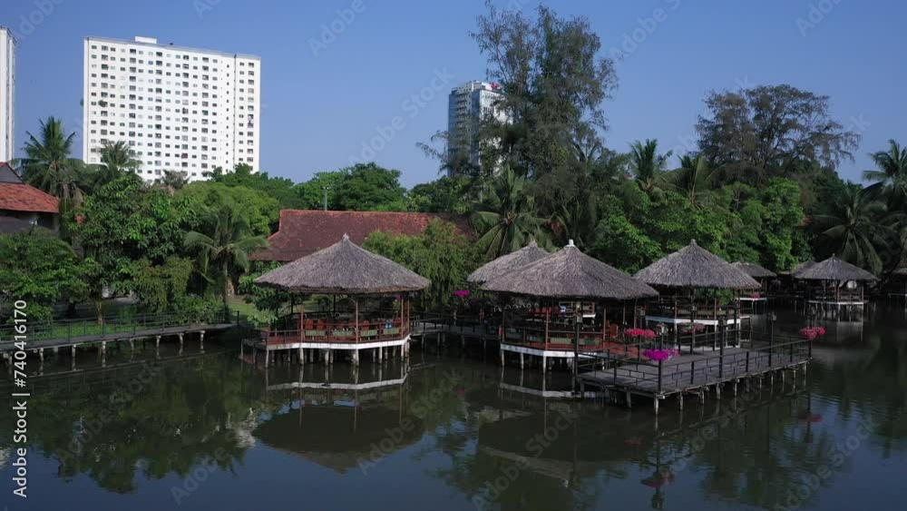 Restaurant ơn Văn Thánh Lake with private thatched huts and marina. A popular park and scenic spot for locals and tourists in Binh Thanh District in Ho Chi Minh City, Vietnam on a clear sunny day. Restaurant ơn Văn Thánh Lake with private thatched huts and marina. A popular park and scenic spot for locals and tourists in Binh Thanh District in Ho Chi Minh City, Vietnam on a clear sunny day.