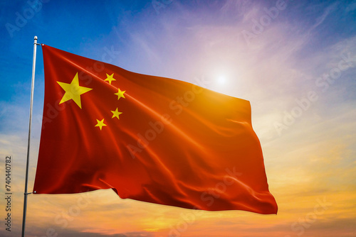 Chinese national flag with blue sky as background . With sunlight .Chinese flag waving in the wind on a sunny day


