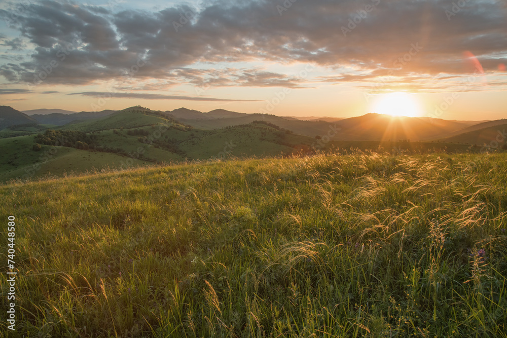 Evening rural landscape, the setting sun, sunset, spring nature, meadows and hills	