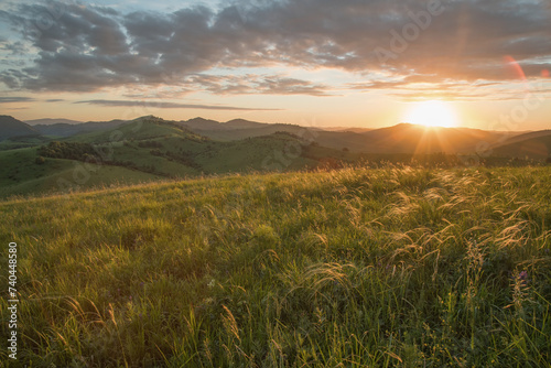 Evening rural landscape, the setting sun, sunset, spring nature, meadows and hills 