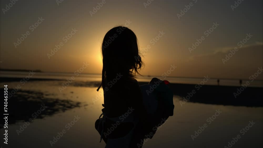 Slow motion of a latin brunette mother carrying her son spinning around laughing and enjoying a warm afternoon at the beach with the sunset behind Slow motion of a latin brunette mother carrying her son spinning around laughing and enjoying a warm afternoon at the beach with the sunset behind