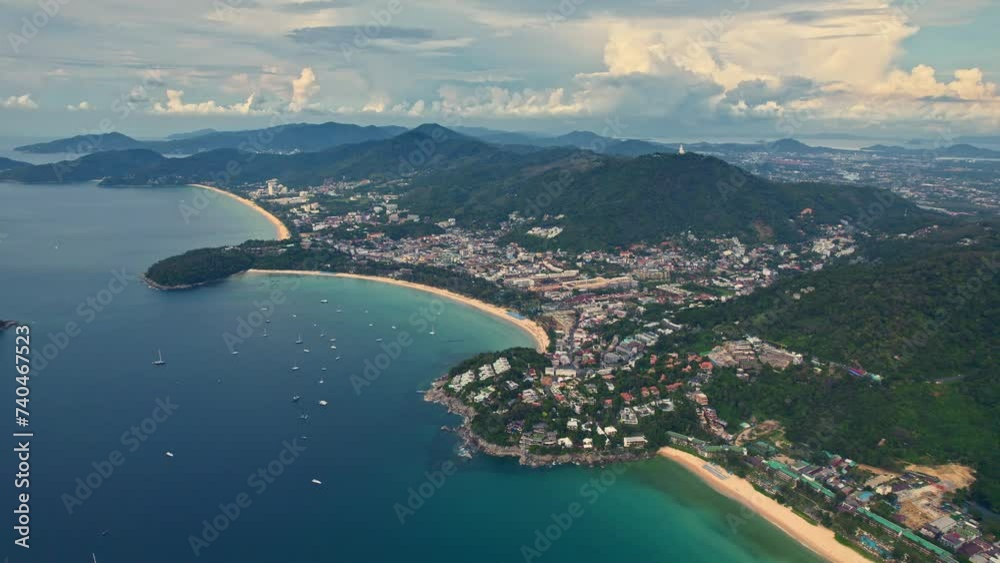 Tropical beach surrounded by mountains, water, and clouds in aerial view. View of the beaches of Kata and Karon, Phuket islands. Tropical beach surrounded by mountains, water, and clouds in aerial view. View of the beaches of Kata and Karon, Phuket islands.