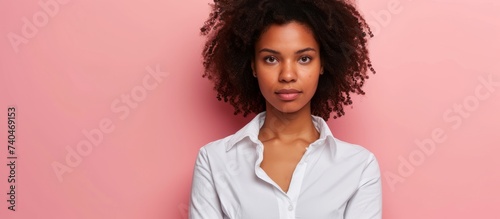 Portrait of a young woman with curly hair wearing a stylish white shirt in a studio photoshoot photo