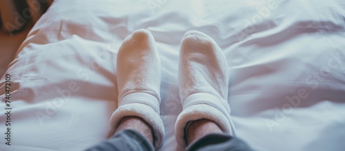 Cozy feet under white sheets in comfortable bed concept for relaxation and sleep photo