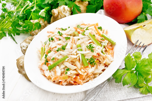 Salad of Jerusalem artichoke and apple in plate on board