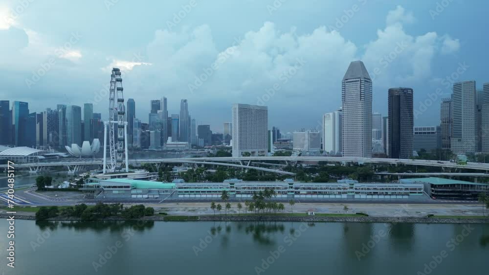 Drone wide orbiting shot of Formula 1 One Paddock Area. Street Circuit Racing Track, Singapore skyscrapers, Helix Bridge, Suntec City in background. Singapore Tourism Establishing shot Drone wide orbiting shot of Formula 1 One Paddock Area. Street Circuit Racing Track, Singapore skyscrapers, Helix Bridge, Suntec City in background. Singapore Tourism Establishing shot