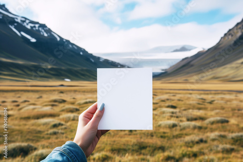 Hand holding white paper and mountain background. AI Generative