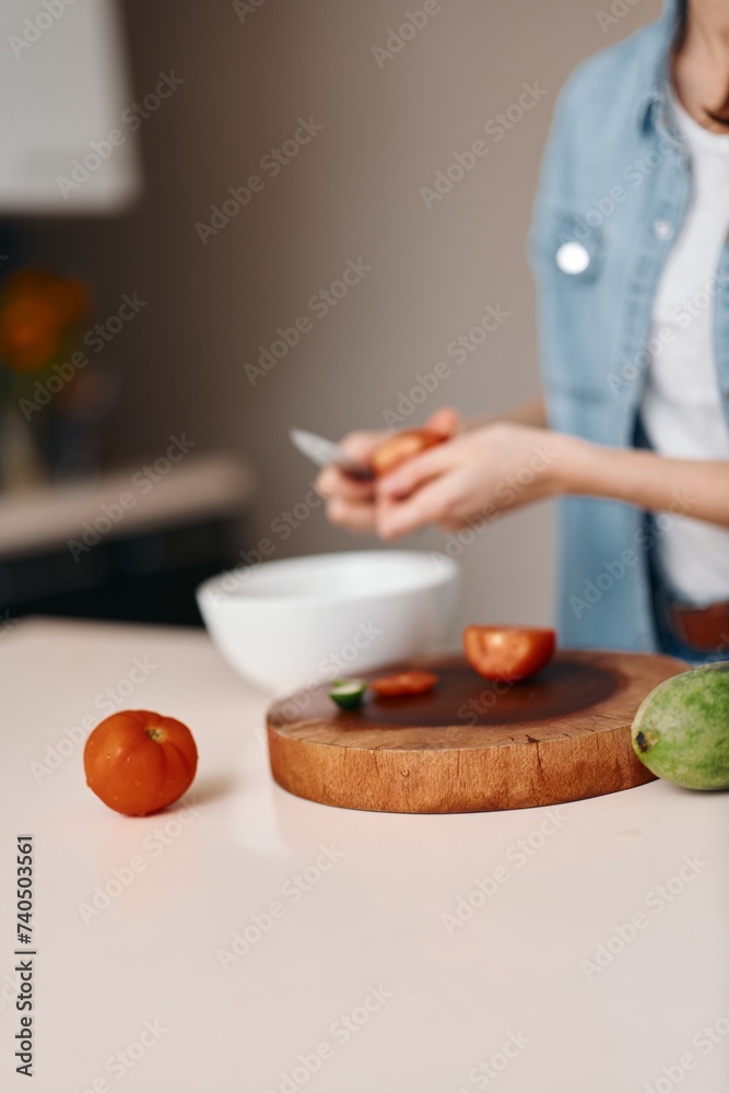 Close-up of a woman preparing a fresh spring vegetable salad in her kitchen