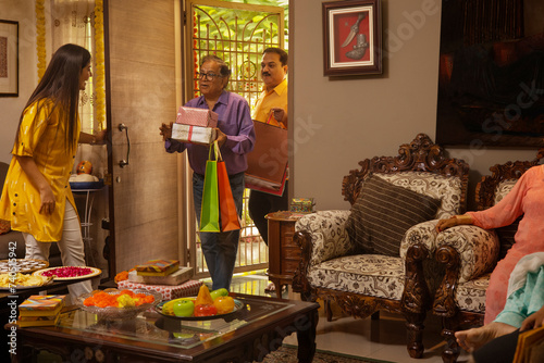 Father and son entering home with gifts purchased for their family on the occasion of Diwali  photo