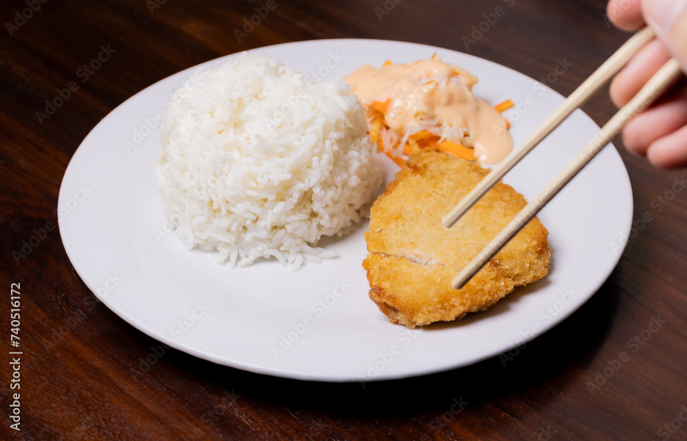 Rice with chicken katsu in white plate on wooden table. After some edits.