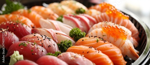 A close up of a beautifully arranged plate of sushi, featuring fresh fish slices, seafood, and fine herbs as garnish. The perfect dish for seafood cuisine enthusiasts