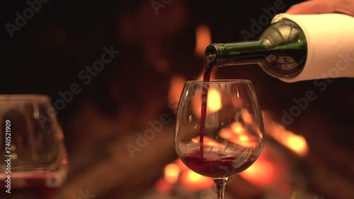 Dinner by the fire put wine in the glass photo