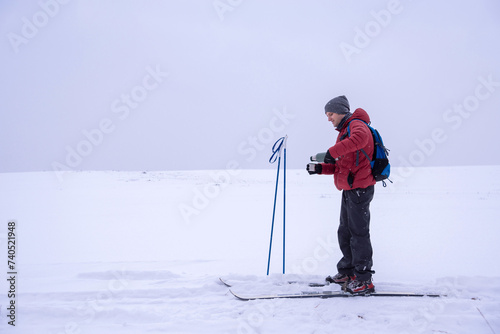 Backcountry Skier Pouring Tea From a Vacuum Flask