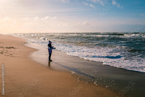 Boy playing on the beach on the Baltic Sea in winter