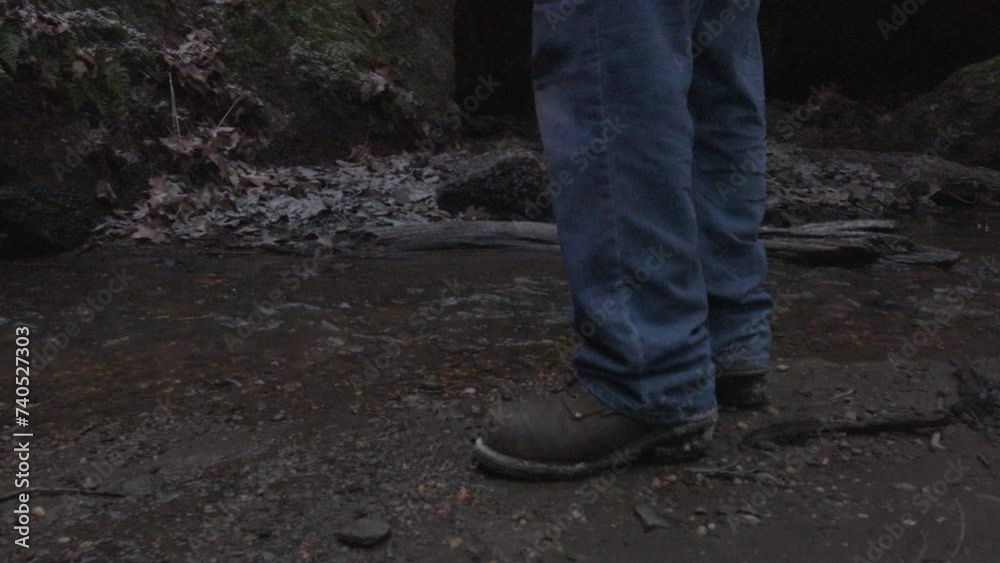 close up of a hikers boots as he approaches a stream where he reaches into his backpack to retrieve a tin cup to get water from the creek close up of a hikers boots as he approaches a stream where he reaches into his backpack to retrieve a tin cup to get water from the creek