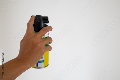 Hand holding an aerosol can of insecticide. Mosquito or insect spray with white background. photo