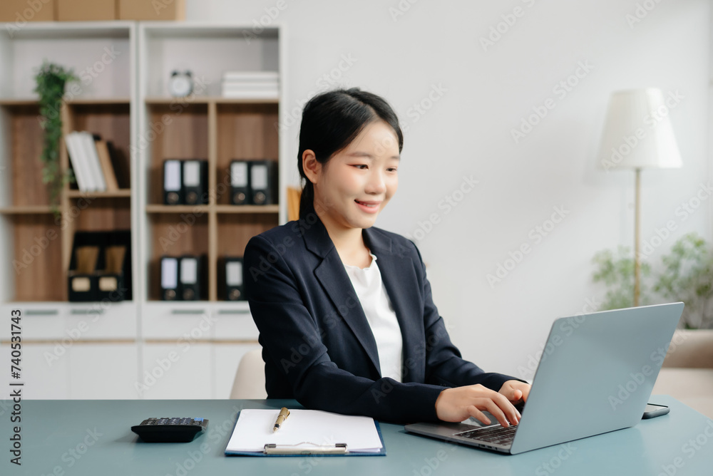 Young beautiful woman typing on tablet and laptop while sitting at the working white table Young beautiful woman typing on tablet and laptop while sitting at the working white table