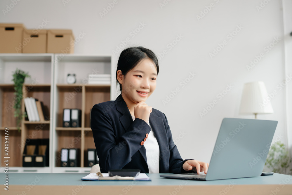 Young beautiful woman typing on tablet and laptop while sitting at the working white table Young beautiful woman typing on tablet and laptop while sitting at the working white table