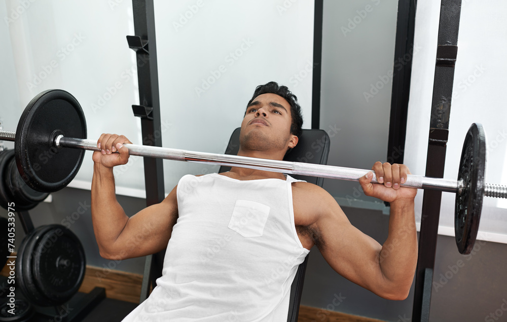 Fototapeta premium Bench, press and man at gym for exercise, workout and body building in Mexico. Healthy, person and weightlifting challenge for strong muscle, fitness or progress in training arms with barbell in club