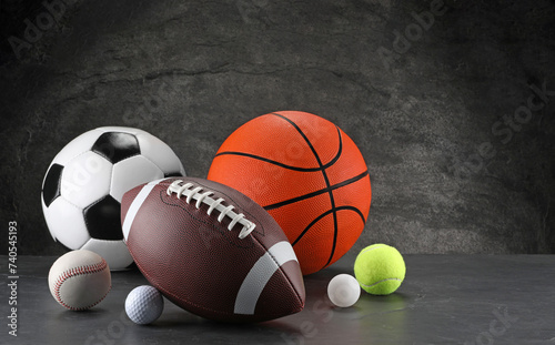 Many different sports balls on dark gray background, space for text