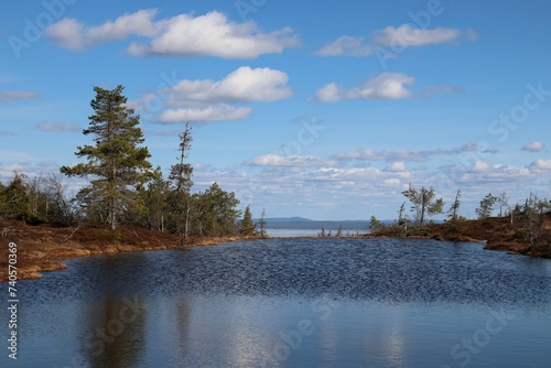 A beautiful scenery of a mountain lake on a wonderful sunny day. The photo is taken in Riisitunturi National Park in Finnish Lapland. Riisi mountain is popular among hikers and nature tourists. photo