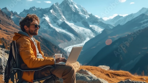Freelancer working in laptop in the wilderness. Man working in computer with mountain view.